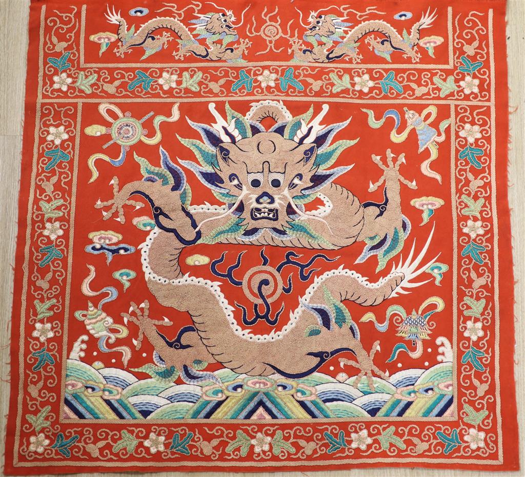 A early 20th century Chinese red felt square panel embroidered with a central motif of a dragon, width 86cm height 84cm